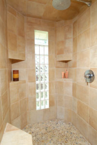 Tile and stone shower detail with window and candle